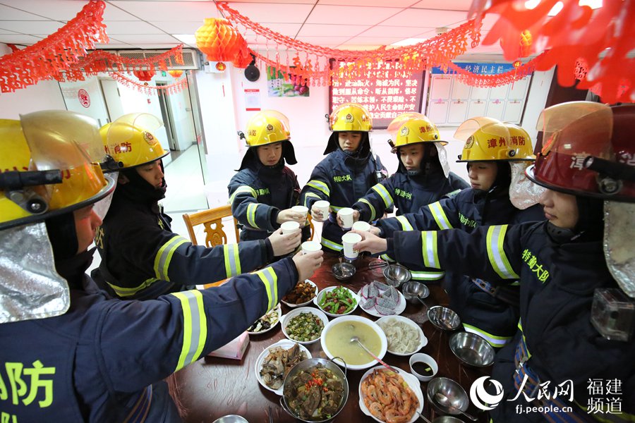 漳州消防特勤大隊一中隊消防指戰(zhàn)員歡聚一堂，吃年夜飯，舉杯共飲。