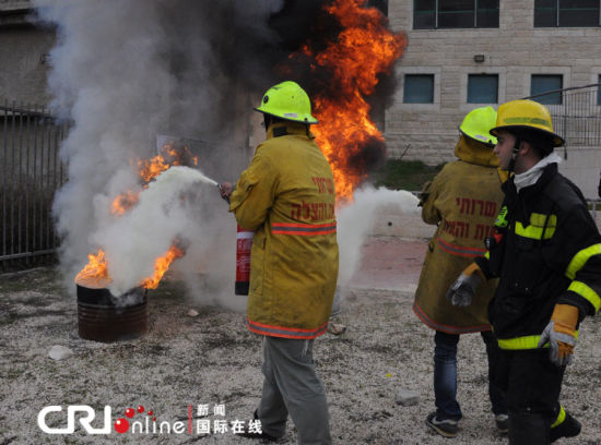 兩名志愿者在消防員的指揮下滅火。（攝影：張瑾） 