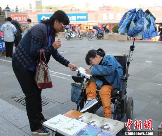 洛洛正在給買書的顧客簽名。 馮曉林 攝